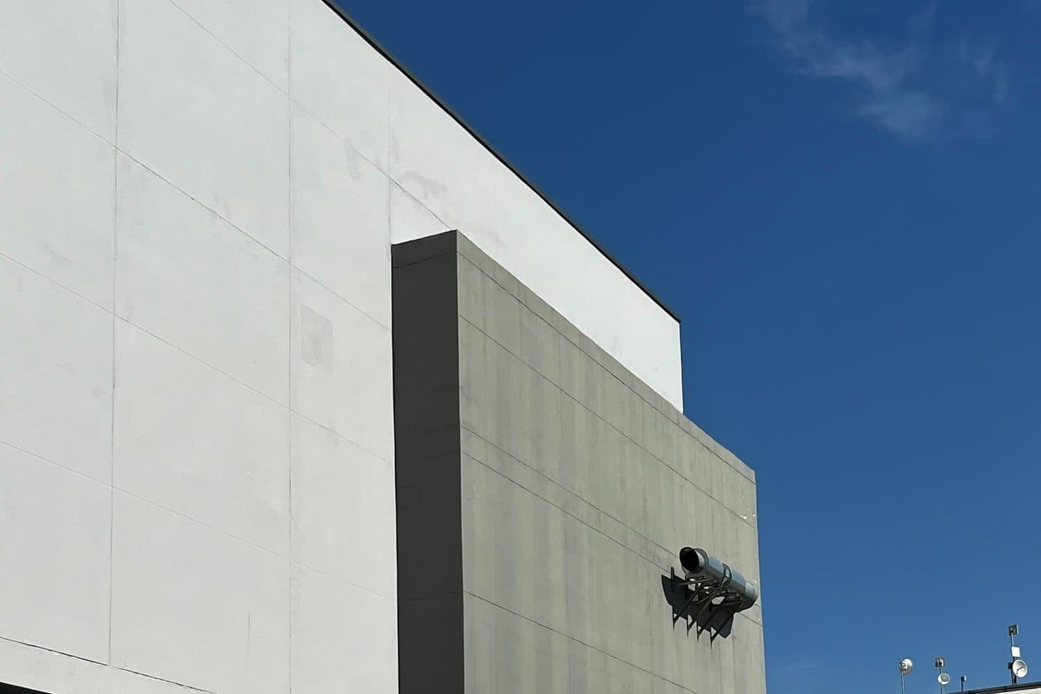 Nave industrial de concreto con andén de carga bajo cielo despejado